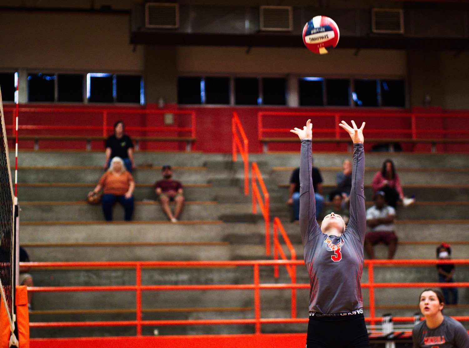 Mylee Fischer sets the ball high as Audrey Dowdle prepares for a spike. [Dig this? Get a print.]